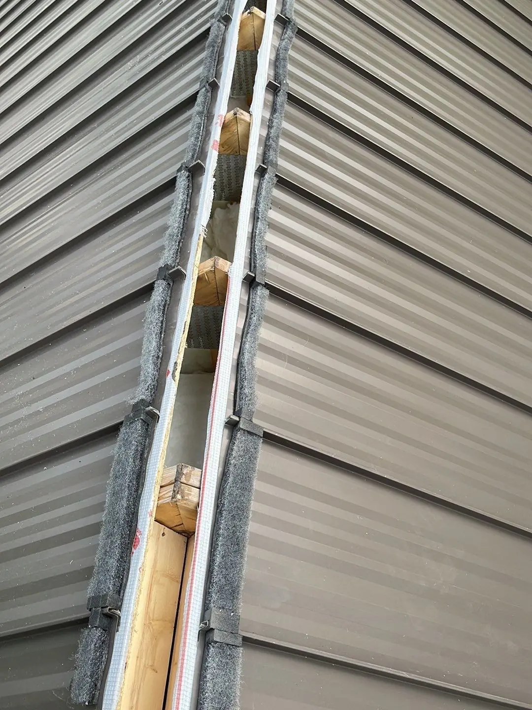 Close detail of a bronze-tan standing seam ridge cap