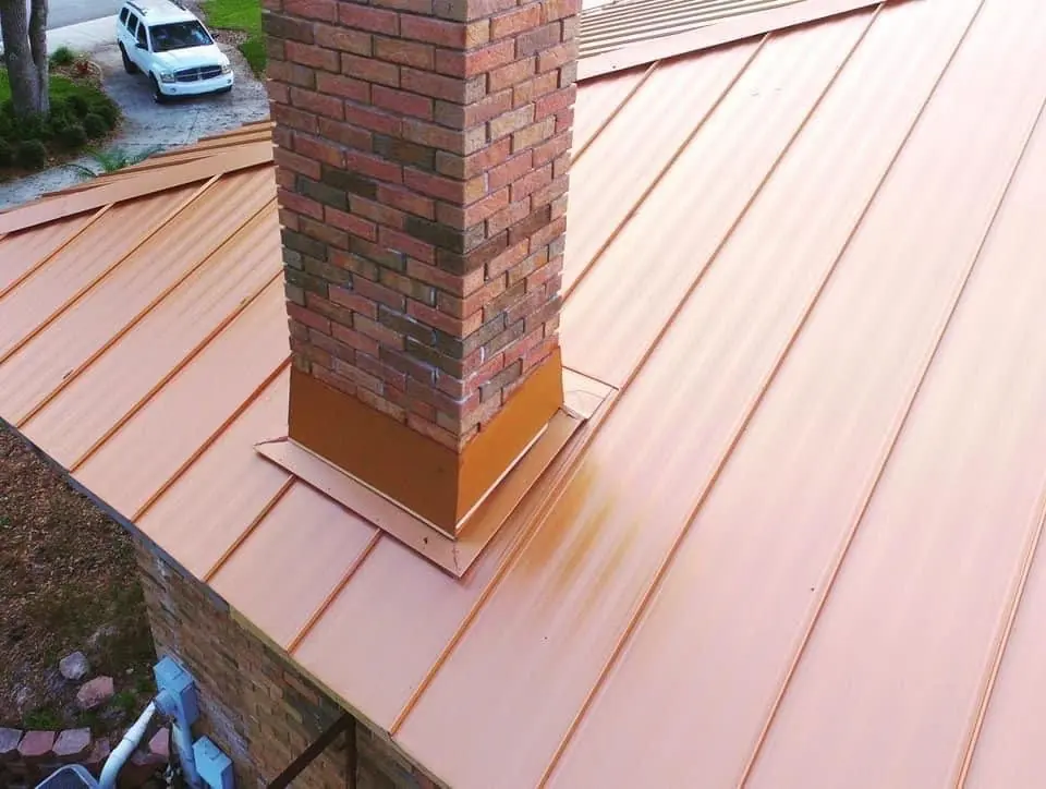 Salmon-toned standing seam roof with brick chimney detail