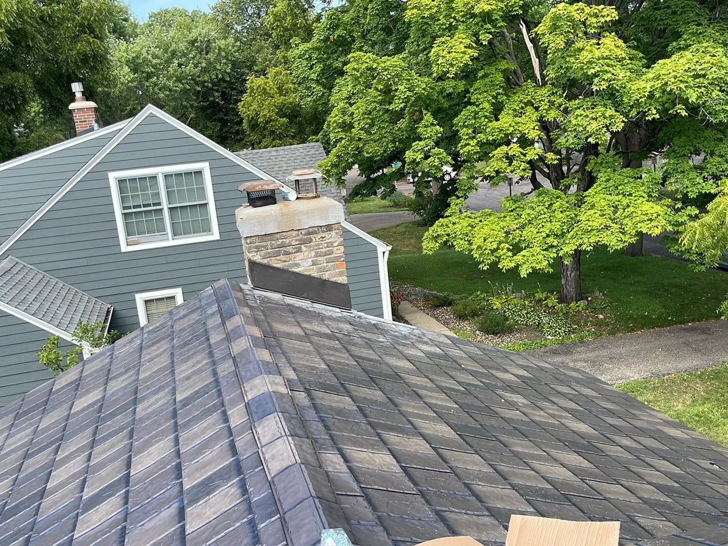 Finished valley on a dark blue-gray synthetic slate roof in Edina, Minnesota
