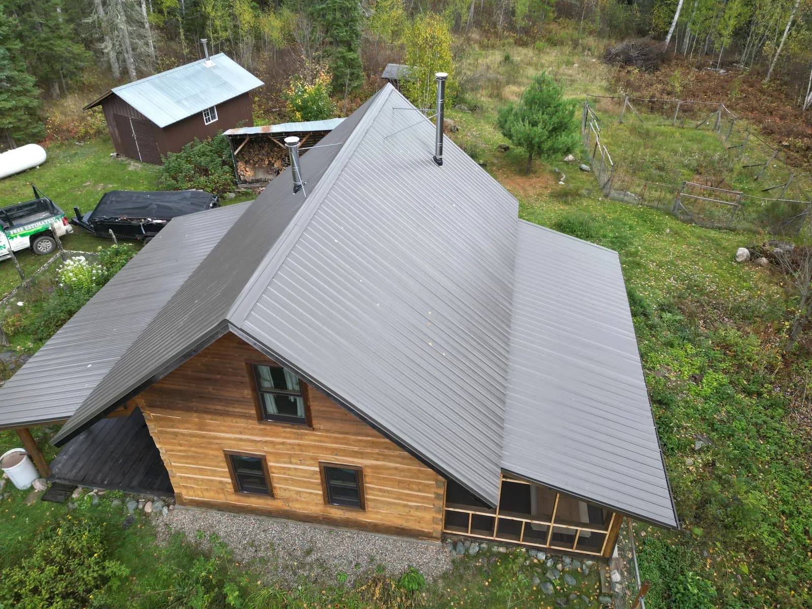 Gray-brown standing seam metal roof on a steep A-frame log cabin near Ely, Minnesota